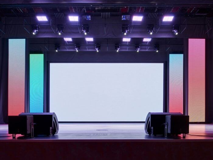 An empty conference stage, lit up multi coloured blocks.